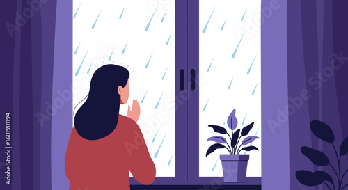 Woman looking out the window at rain while standing indoors  