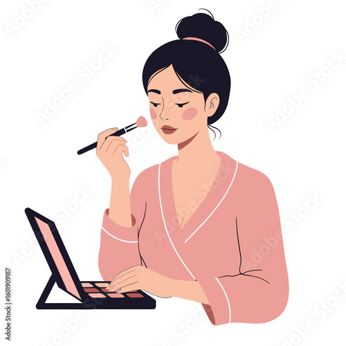 Young woman applying blush while sitting at vanity with makeup palette  