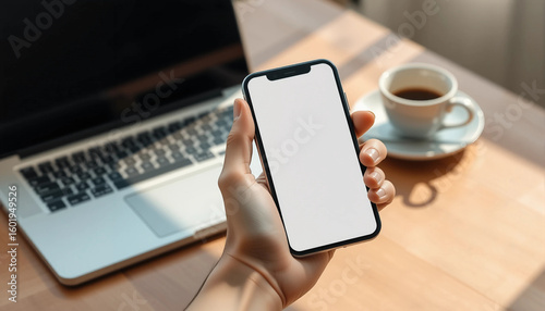 Hand Holding Smartphone with Blank Screen at Workspace – Mockup for App or Website Design.