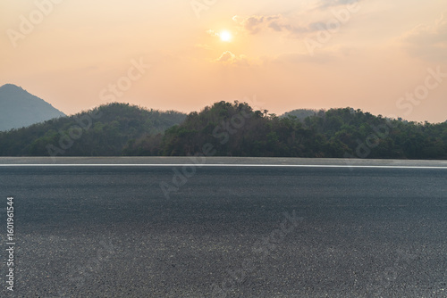Side view of asphalt road with landscape of sunset sky. Road background