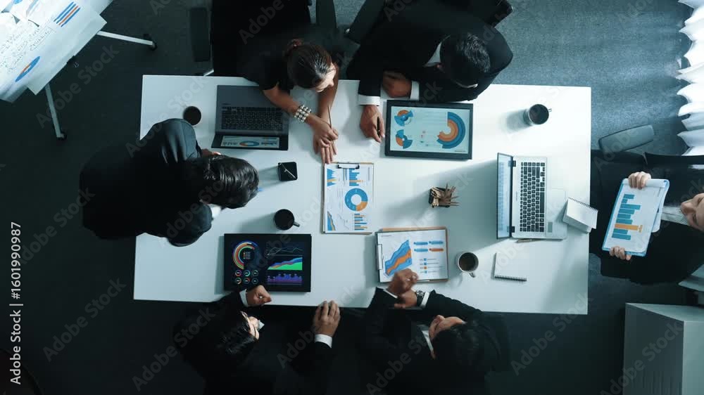 Top down aerial view of manager standing and present business plan to skilled investor. Business team working together to analyze financial statistic graph at meeting table. Time lapse. Directorate.