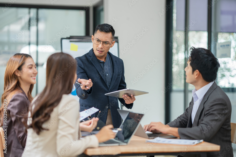 Fototapeta premium Group of business people are standing in a meeting presenting their work at the office.
