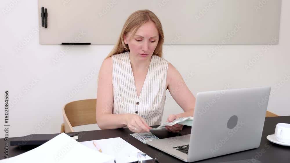Businesswoman analyzing financial documents while working on laptop in modern office environment, showcasing professionalism and focus on tasks Businesswoman analyzing financial documents while working on laptop in modern office environment, showcasing professionalism and focus on tasks
