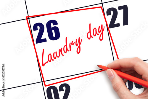 26th day of the month.  Hand writing Laundry day reminder and drawing red frame on calendar with red pen on white background. Concept of home planning and scheduling. Planning and scheduling