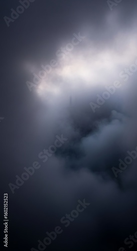 Dramatic sky with dark clouds, illuminated by a hidden light source creating a sense of mystery