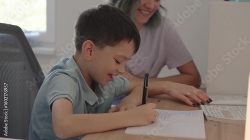 A happy mother assists her son with his homework, fostering a loving and supportive learning environment.