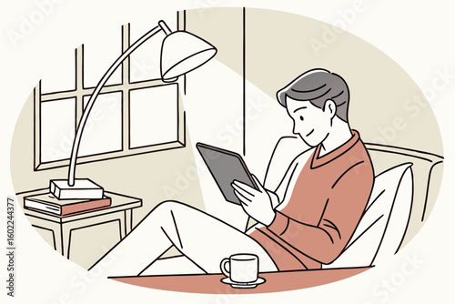 Comfortable man enjoying a digital book while relaxing in a cozy living room during the afternoon