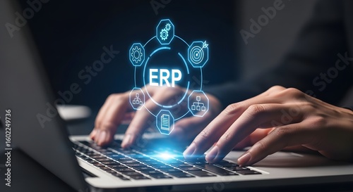 Hands typing on laptop with glowing erp technology interface above keyboard