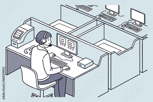 Customer service representative engaged in work at a modern office cubicle setup with computers and a headset during business hours