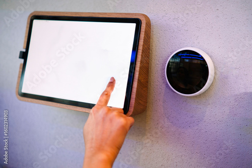 Finger interacting with smart home touchscreen panel indoors