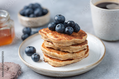 Stack of oat pancakes with blueberries on a plate, closeup view