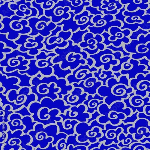 Swirling silver clouds in seamless Asian style pattern on blue, perfect for fabric, wrapping or print design