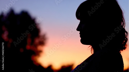 Pregnant woman's silhouette with glowing baby outline against sunset, embodying maternal love and new beginnings