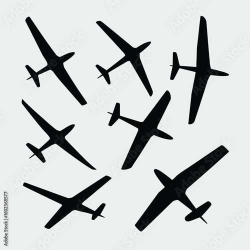 Silhouettes of various airplanes in flight against a light background