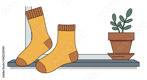 Cozy yellow socks resting on a windowsill beside a potted plant  