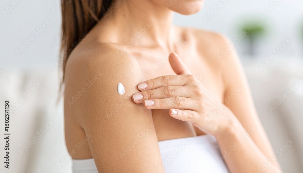 Fototapeta premium Woman Applying Moisturizing Lotion to Skin Skincare Routine.