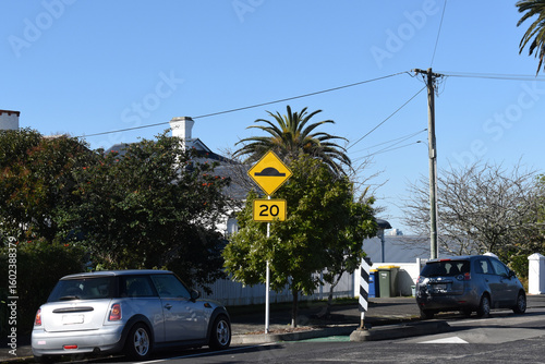 Photography PW-39 hump sign on road with 20 speed limit sign in Auckland New Zealand