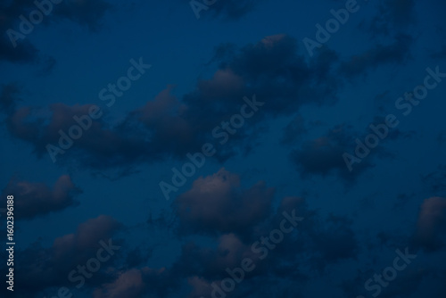 Wallpaper Mural A large, dark cloud floats in a deep twilight sky, tinted with faint pink light, creating a minimalist, moody scene with ample space for text. Torontodigital.ca