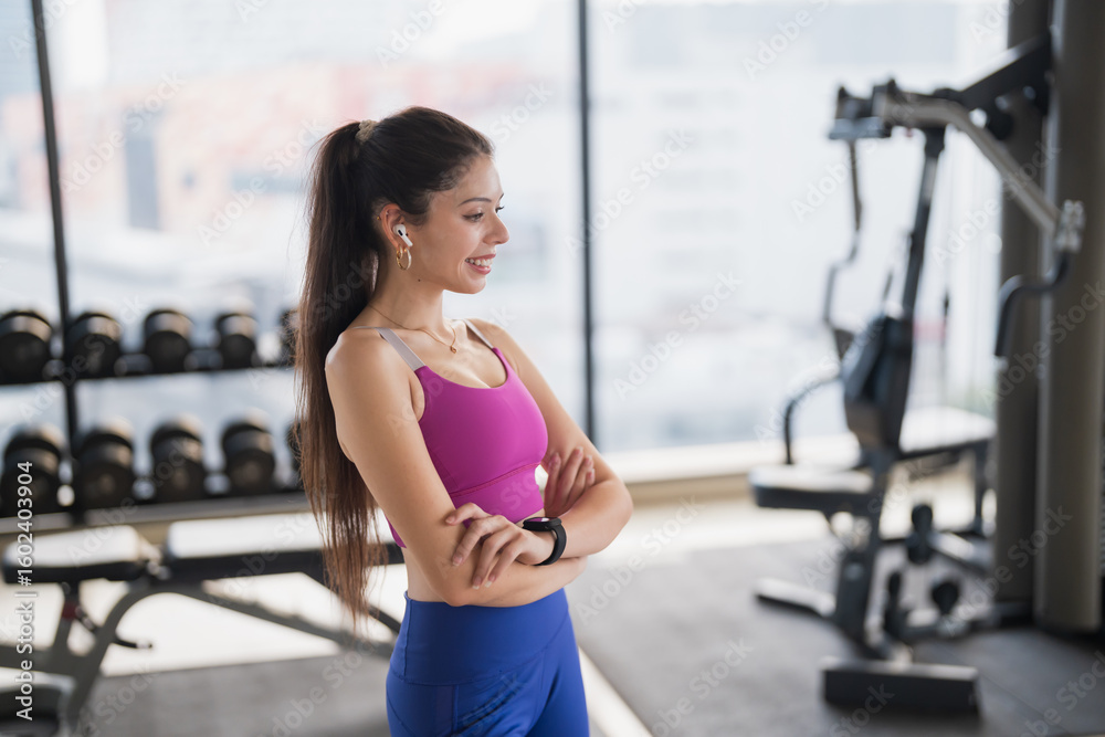 Fototapeta premium Portrait of Healthy Young Hispanic Gen Z Woman in Sportswear at Gym Embracing Wellness and Self-Love.