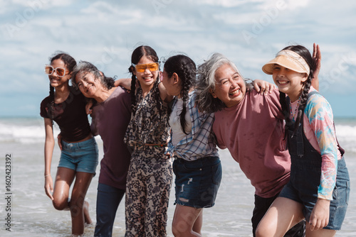 Photos Happy Asian family group, senior women and kids enjoying playful beach