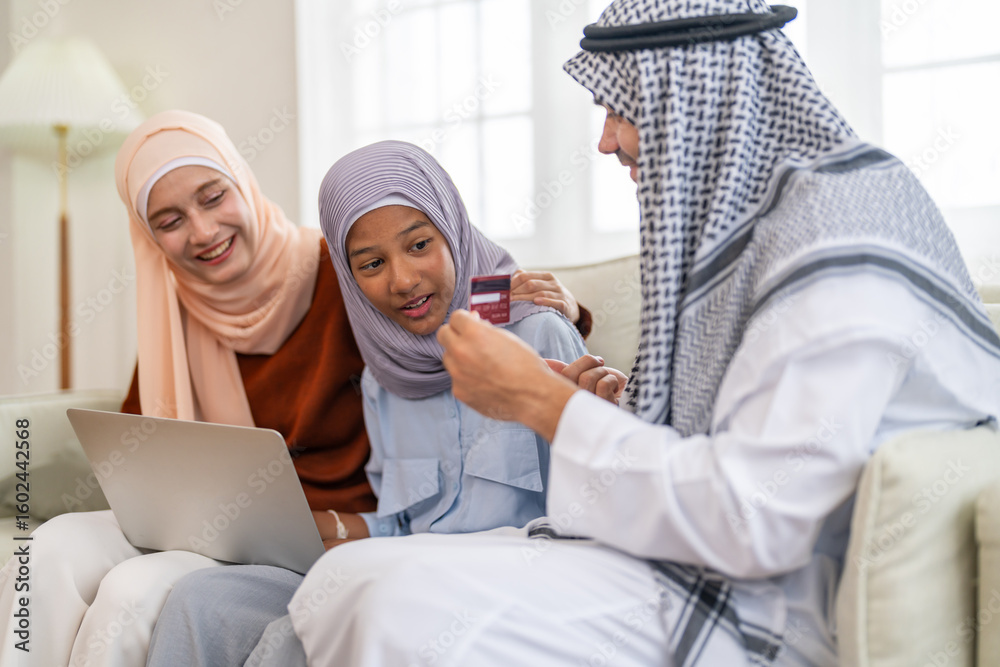 Obraz premium Muslim family using tablet for online shopping and holding credit card, islamic digital lifestyle and modern islamic banking, e-commerce trends, halal marketplace and islamic finance family planning