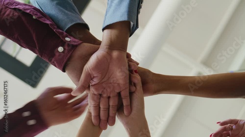 Closeup of diverse business people stacking hands in office