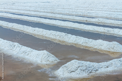 Pyramids of sea salt ready to be harvested in a salt farm at sunrise. Used as a seasoning in food, cosmetics and for food preservation.