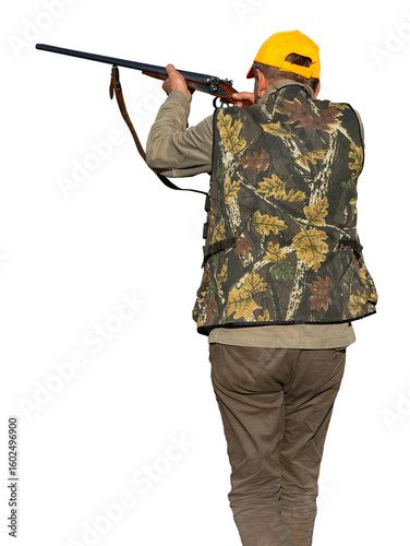 Hunter aiming with rifle while standing against sky