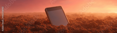 Nature escape from tech,phone partially buried in soil at sunset creates striking scene that invites escape from tech and reconnect with nature