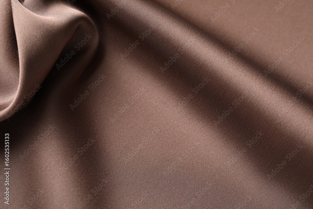 Fototapeta premium Crumpled light brown silk fabric as background, closeup