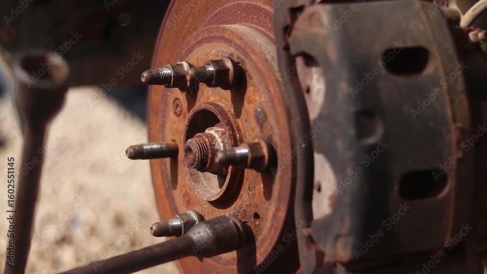 Close up of a car wheel hub with a cross wrench being used to tighten a lug nut Close up of a car wheel hub with a cross wrench being used to tighten a lug nut