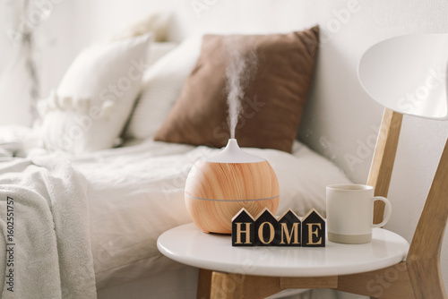 Aromatherapy Concept. Aroma oil diffuser on chair against in the bedroom. Air freshener. Ultrasonic aroma diffuser for home