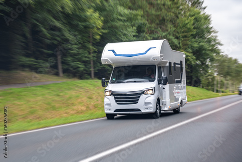 Fotografie White camper van on road. Travel motion blur. Speed and freedom