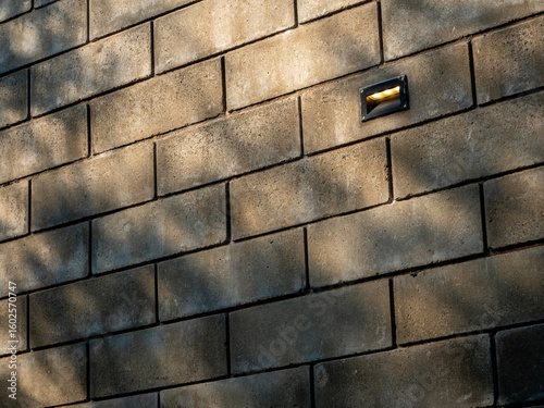 Shadows of trees cast on a large brick wall