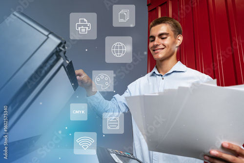Young man using a multifunction printer to copy documents in an office setting during daytime