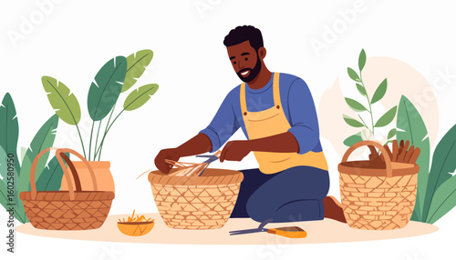 Smiling Black artisan with a beard, wearing a yellow apron, kneels while weaving a wicker basket.