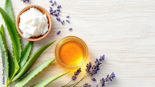 Overhead shot of shea butter, honey, aloe vera, and lavender on a white wooden surface