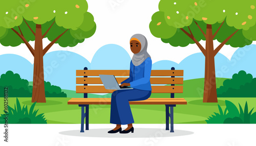 A Black woman in a grey hijab and blue attire sitting and working on her laptop.