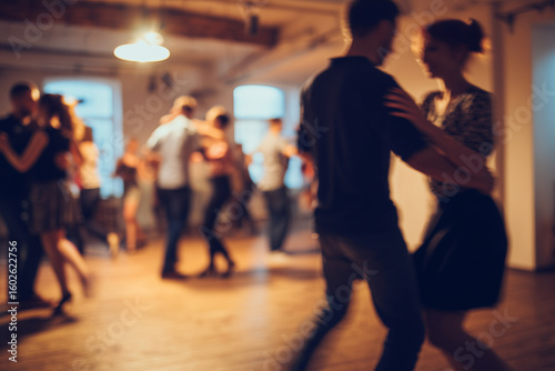Dancing couples in a cozy room with warm lighting and blurred background