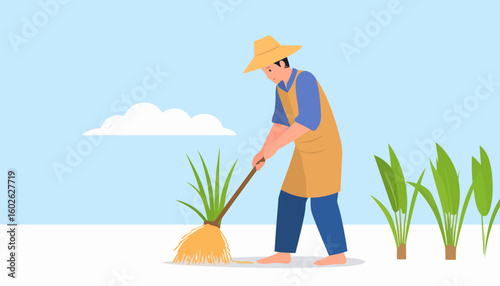 Barefoot farmer in a yellow hat and apron using a tool to tend to green plants in a field.