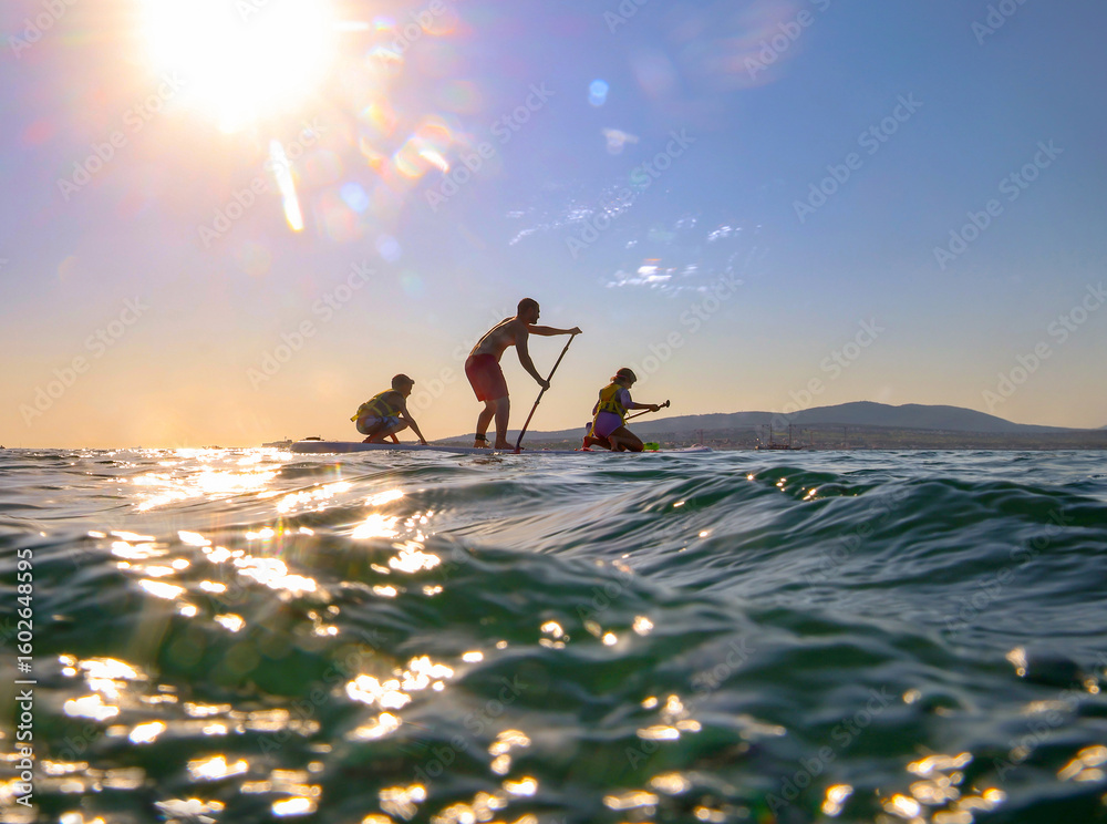 Fototapeta premium family with kids riding on sup surfing in the sea at summer day.