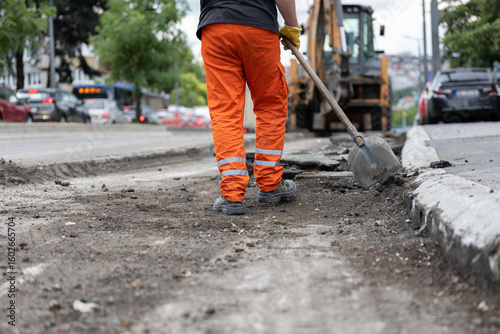 Bild auf Leinwand Construction worker repairs road on city street during daytime
