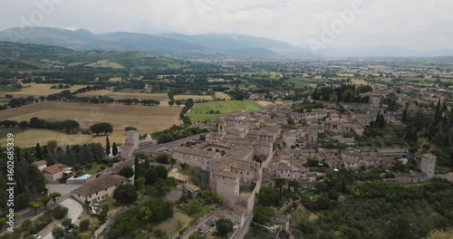 Wallpaper Mural Aerial view of Spello's cityscape, the view shows a cluster of buildings and towers nestled among rolling hills and mountains, Spello, Umbria, Italy. Torontodigital.ca