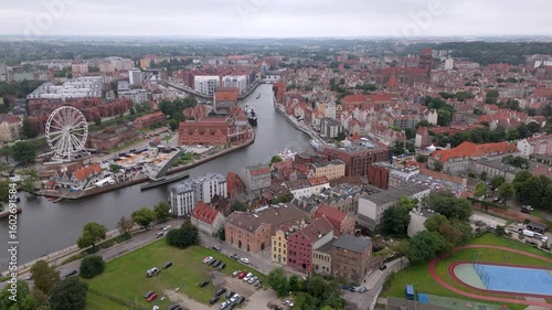 Aerial view of Gdansk Old Town, historic architecture along the Motlawa River, ferris wheel and marina, overcast day in northern Poland