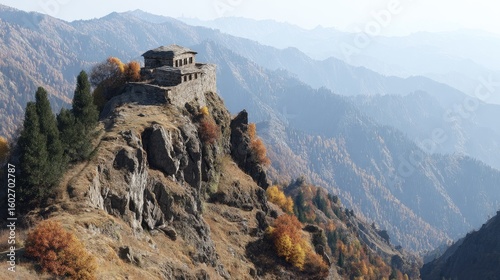 A weathered stone structure, possibly a ruin or ancient temple, perches atop a rocky outcrop amidst autumnal mountain ranges.  The hazy atmosphere and muted colors suggest a tranquil, remote setting