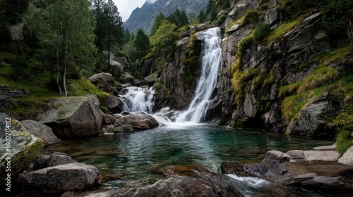 Mountain waterfall cascading down rugged cliffs with crystal-clear water flowing over moss-covered rocks