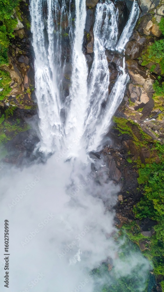 Naklejka premium Overhead View of Tropical Waterfalls Surrounded by Lush Green Forest and Mist