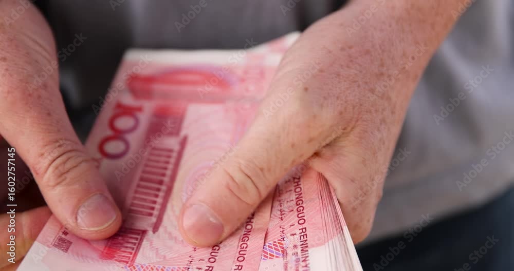 holding a stack of money yuan in his hand on a background, holding a large amount of money in yuan in the hands of a man