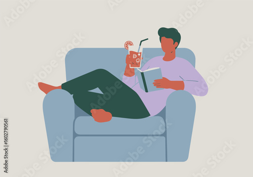 A man relaxes in a blue armchair, reading a book and enjoying a refreshing drink with a straw.