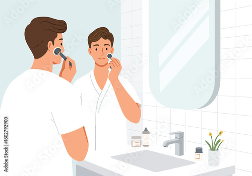 A man shaves his face in the bathroom, looking at his reflection in the mirror.